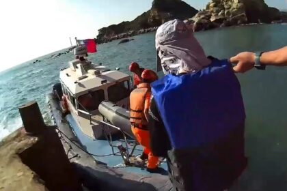 A handout photo from the Taiwan Coast Guard shows a Chinese national (in blue), who was ca