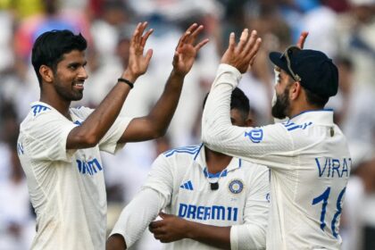 India's Washington Sundar celebrates with his teammate Virat Kohli (R) after taking the wi