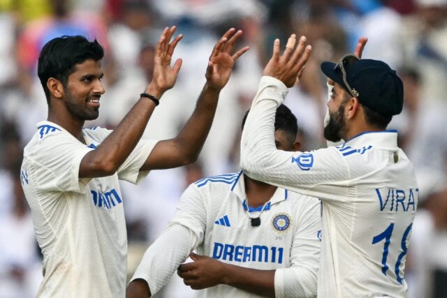 India's Washington Sundar celebrates with his teammate Virat Kohli (R) after taking the wi