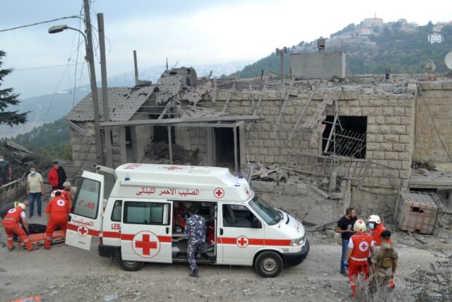 Lebanese Red Cross paramedics transport a body unearthed from the rubble at the site of an