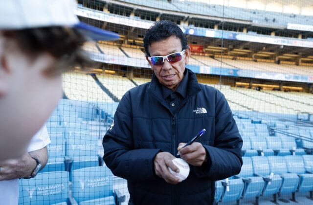 Former Los Angeles Dodgers pitching great Fernando Valenzuela autographs a ball for fans b