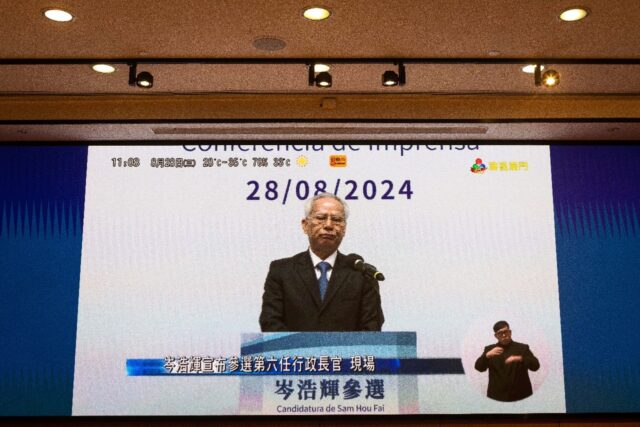 Macau's new leader Sam Hou-fai is seen on a screen during a news conference in August when