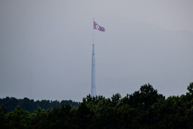 A North Korean flag seen from Paju in South Korea flutters over the village of Gijungdong