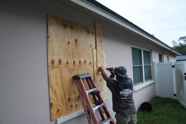 A resident boards up his windows in Palm Harbor, Florida, ahead of Hurricane Milton's expe