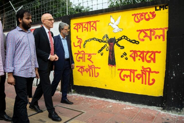 UN rights chief Volker Turk (C) looks at graffiti on the walls of Bangladesh's Dhaka Unive