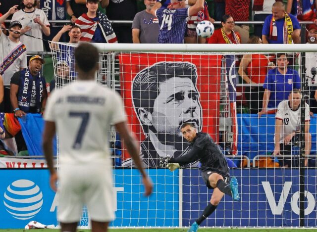 USA goalkeeper Matt Turner clears the ball in front of a banner of head coach Mauricio Poc