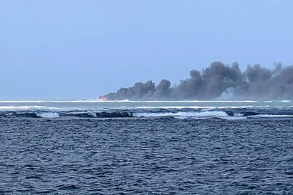 The New Zealand navy vessel ablaze on October 6, 2024, seen from Samoa's Tafitoala Beach i