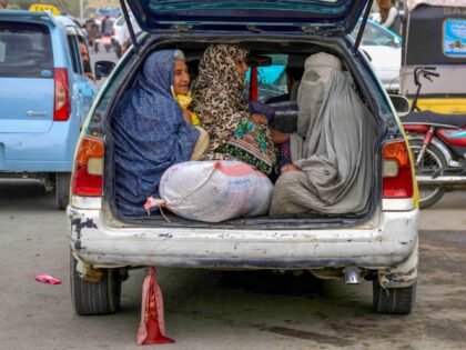 Afghan women sit at the back of a local taxi along a road in Kandahar on October 29, 2024.