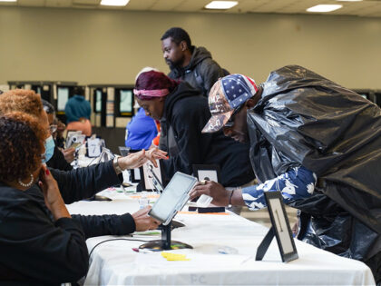 ATLANTA, GEORGIA - NOVEMBER 5: Derek Stevenson wears a trash bag and a Trump hat to cast h