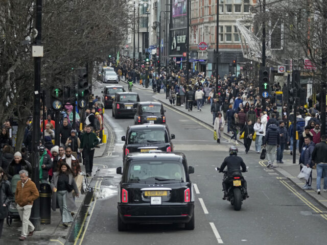 FILE - Shoppers walk along Oxford Street during the Boxing Day sales in London, Tuesday, D