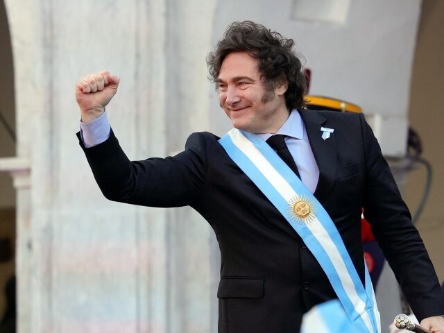 Argentine President Javier Milei holds out his fist during a ceremony celebrating the 214t