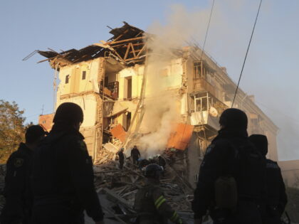 Rescue workers clear the rubble of a residential building destroyed by a Russian airstrike