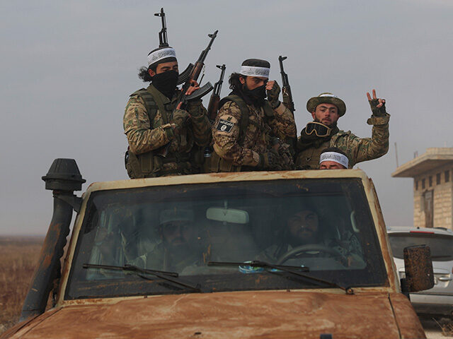 Syrian opposition fighters ride in a truck in Talhiya, Idlib countryside, Syria, Friday, N