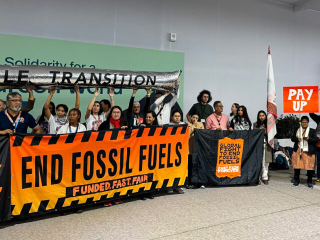 Climate activists stage a protest inside the COP29 venue to demand a phase out of fossil f