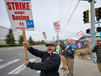 Boeing Machinists Union member Nico Padilla yells "strike" to passing cars with