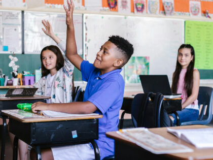 Children in school raising hands