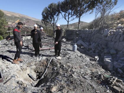 People observe the site where an Israeli airstrike hit a compound housing journalists, kil