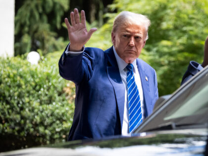 Former President Donald Trump waves to supporters after meeting with Senate Republicans at