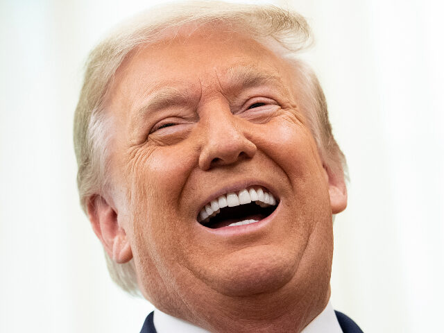 US President Donald Trump laughs during a Medal of Freedom ceremony for Lou Holtz in the O