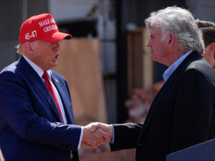 Republican presidential nominee former President Donald Trump shakes hands with Rev. Frank