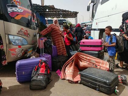 Passengers fleeing war-torn Sudan disembark at the Wadi Karkar bus station near the Egypti