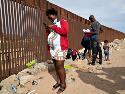 YUMA, ARIZONA - DECEMBER 07: An immigrant family from Haiti waits to be taken into custody