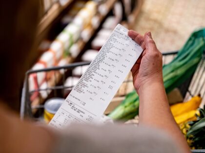 Trump - Close-up on a woman looking at a receipt after shopping at the supermarket - cost