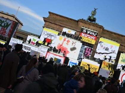 Musicians perform next to screens displaying artworks at Brandenburg gate during celebrati