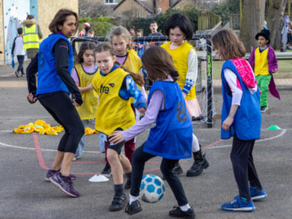 Munira Wilson Liberal Democrat MP for Twickenham plays football with the girls team at a l