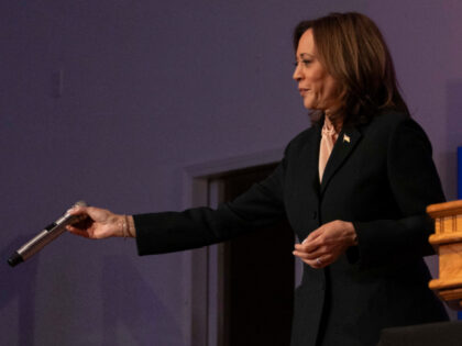 US Vice President and Democratic presidential candidate Kamala Harris hands off the microp