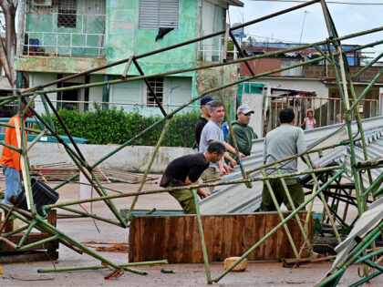 Residents recover their goods at a farmers' market after it was destroyed by Hurricane Raf