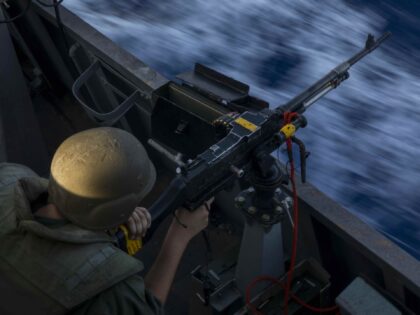 An Israeli soldier fires on board the Israeli Navy Ship Lahav during a rare tour of Israel