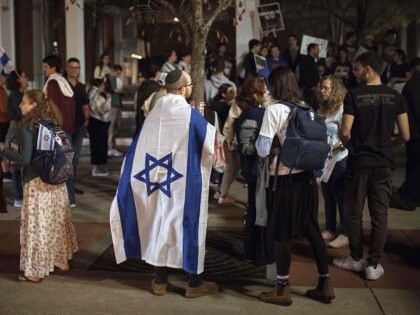 Jewish Rutgers University's students and members of the community gather holding plac