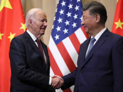 TOPSHOT - US President Joe Biden (L) shakes hands with Chinese President Xi Jinping on the