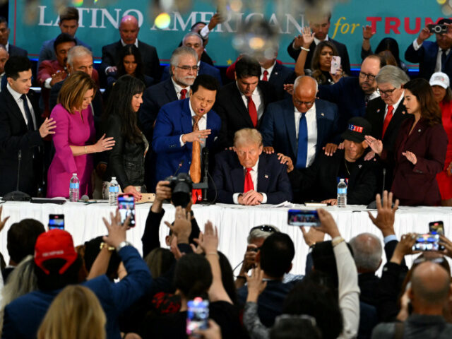 Former US President and Republican presidential candidate Donald Trump prays during a roun