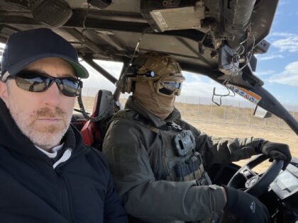 The author and a Yatar guide, with the Gaza border fence in the background. (Joel Pollak /