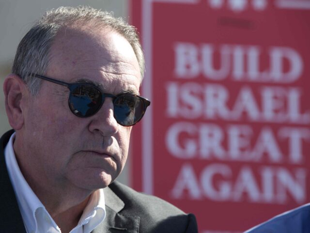 U.S. Governor Mike Huckabee takes questions from the media, prior to laying a brick at a n