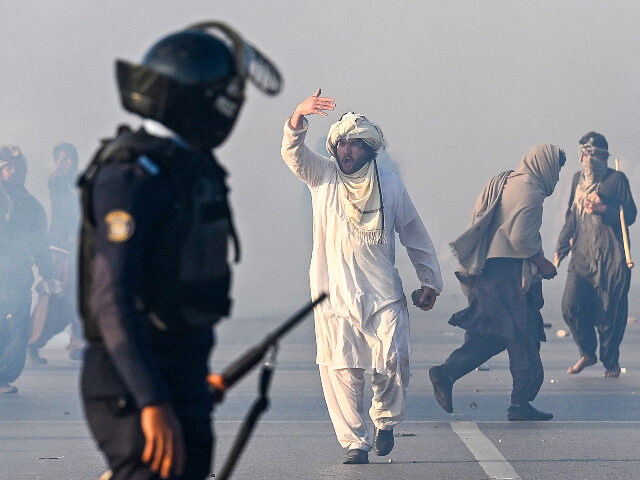 A supporter of Pakistan Tehreek-e-Insaf (PTI) party gestures after tear gas was fired by t