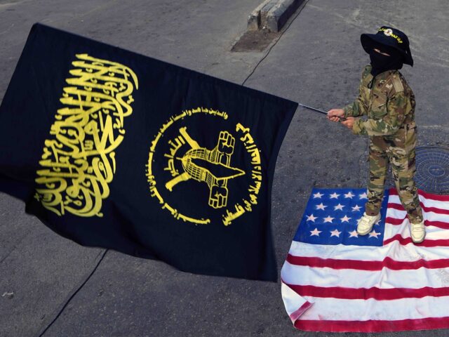 A child waves the Palestinian Islamic Jihad group flag as she stands on an American flag d