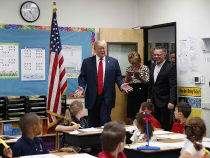 Republican presidential candidate Donald Trump tours a classroom during a visit to the Int