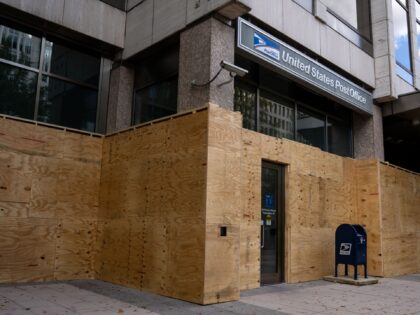 WASHINGTON, DC - NOVEMBER 01: Workers board up ground level storefronts and buildings alon