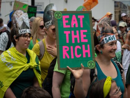 London UK - Jun 22 2024: A woman carries a placard reading "Eat the Rich" at the Restore N