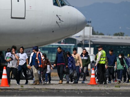 Guatemalan migrants deported from the United States walk on the tarmac after landing at th