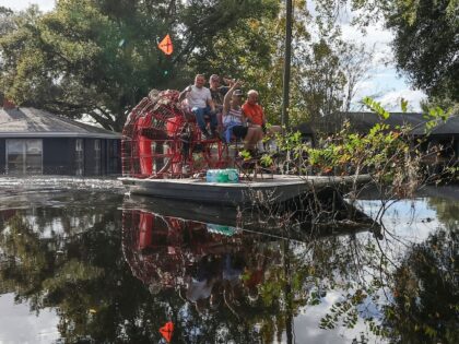 Residents use an airboat to reach dry land in a neighborhood still flooded from Hurricane