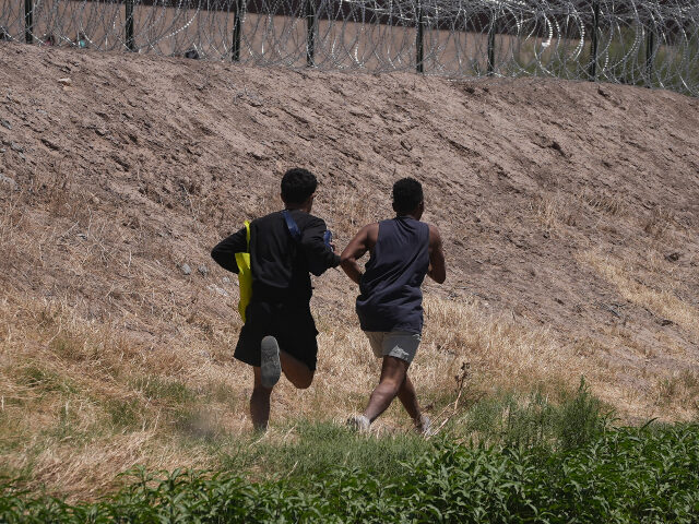 11 May 2023, Mexico, Ciudad Juarez: Two young migrants from Venezuela walk along the Rio B