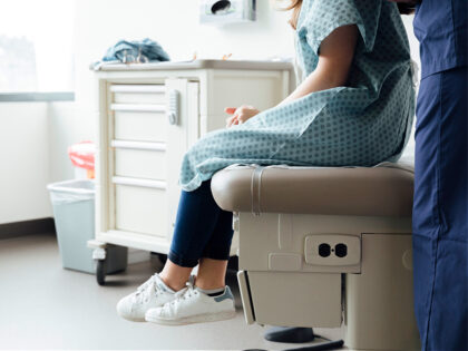 nurse examining patient in clinic - stock photo