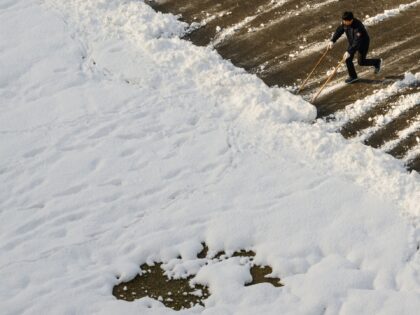 A worker clears snow in Seoul on November 28, 2024, as heavy snowfall blanketed South Kore