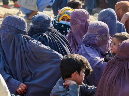 Afghan burqa-clad women refugees wait to cross the Pakistan-Afghanistan border in Torkham