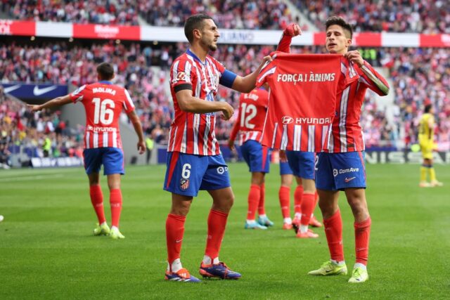 Atletico Madrid's Argentine forward Giuliano Simeone (R) holds a shirt up in support of th