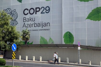 Branding for the COP29 climate conference covers the facade of a building under renovation